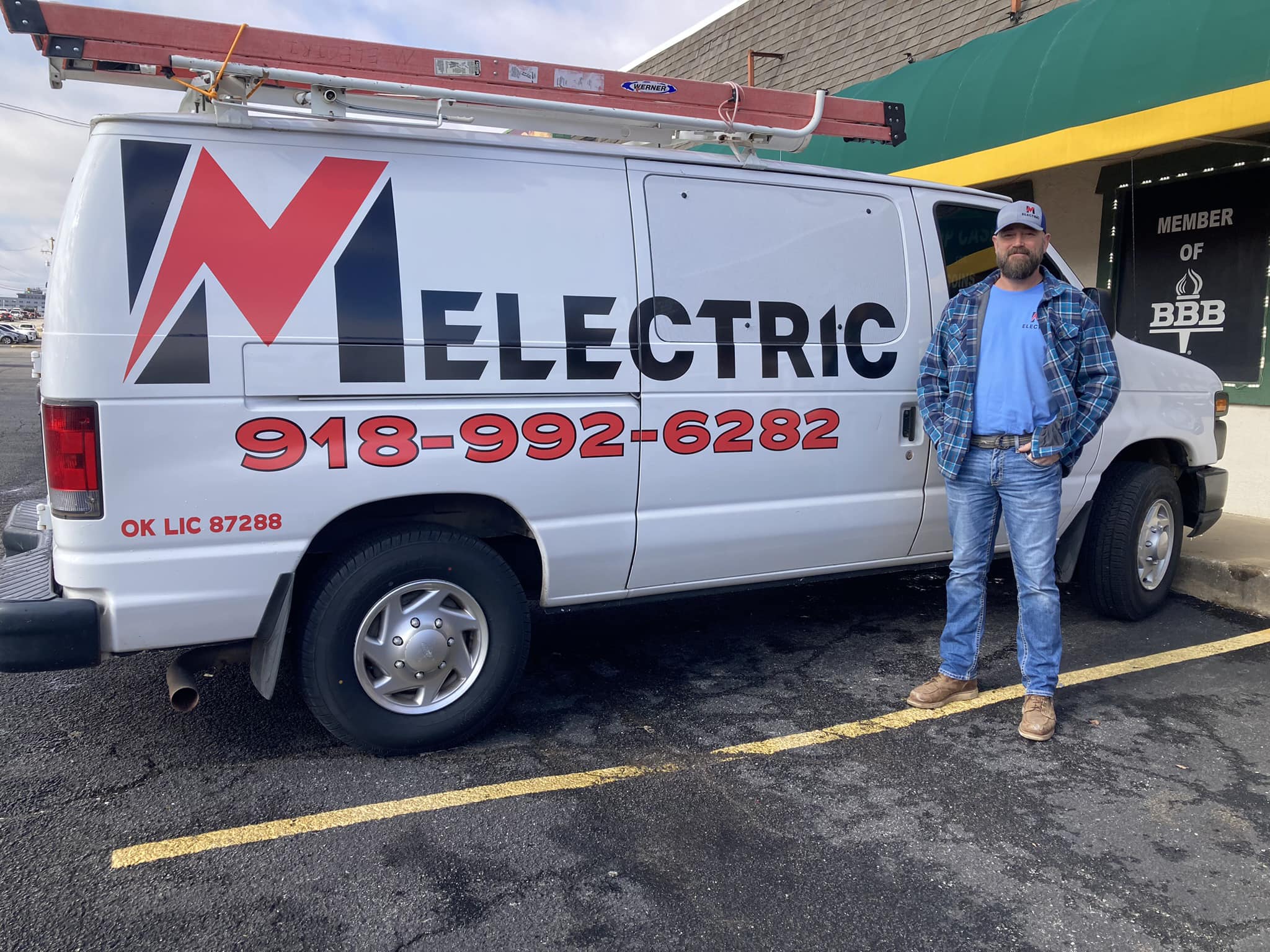 Marshall Morgan, owner of M Electric, standing beside the M Electric service van outside the BBB-accredited business location in Tulsa, Oklahoma